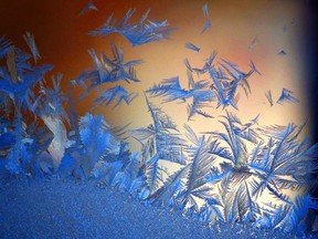 Frost on a car windshield early in the morning, during sunrise.