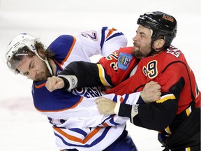 Edmonton Oilers Luke Gazdic, left and Calgary Flames Deryk Engelland fight it out during their game at the Scotiabank Saddledome  in Calgary on January 31, 2015.