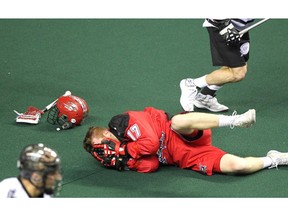 Calgary Roughnecks forward Curtis Dickson lay of the turf after a nasty hit by Edmonton Rush transition Chris Corbeil during NLL game action at the Scotiabank Saddledome on January 24, 2015.
