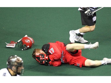 Calgary Roughnecks forward Curtis Dickson lay of the turf after a nasty hit by Edmonton Rush transition Chris Corbeil during NLL game action at the Scotiabank Saddledome on January 24, 2015.