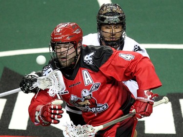 Calgary Roughnecks transition Geoff Snider got tied up with Edmonton Rush transition Jeremy Thompson after a face off during NLL game action at the Scotiabank Saddledome on January 24, 2015.