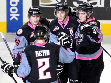 Members of the Calgary Hitmen, clockwise from front left, defenceman Jake Bean, left winger Connor Rankin, centre Adam Tambellini and left winger Jake Virtanen celebrated after Virtanen scored the Hitmen's second goal of the game against the Vancouver Giants during WHL action at the Scotiabank Saddledome on January 25, 2015.