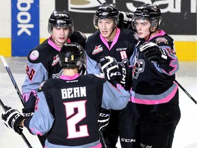 Members of the Calgary Hitmen, clockwise from front left, defenceman Jake Bean, left winger Connor Rankin, centre Adam Tambellini and left winger Jake Virtanen celebrated after Virtanen scored the Hitmen's second goal of the game against the Vancouver Giants on Sunday.