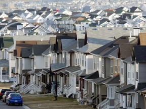 Cookie-cutter subdivision houses rise into the foothills, typical of many Calgary suburbs being built in 2005. This is Tanglewood on Crowchild Trail West.