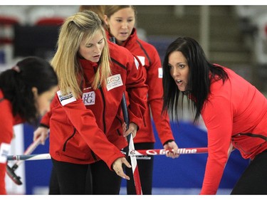 Team Canada curler skip Jennifer Jones, left, helped golfer Lisa "Longball" Vlooswyk with her sweeping on the ice during an fun exhibition match between Team Jones and Brad Jacobs to kick off the Continental Cup at the Markin MacPhail Arena at Winsport January 7, 2015.