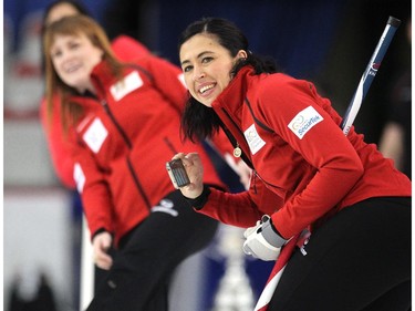 Team Canada curler Jill Officer, right, and Dawn McEwen, background, watched as a rock thrown by golfer Lisa "Longball" Vlooswyk slid down the ice during an fun exhibition match between teams Jennifer Jones and Brad Jacobs to kick off the Continental Cup at the Markin MacPhail Arena at Winsport January 7, 2015.