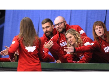 Team Canada members high fived skip Rachel Homan after she won her game against Team Europe's Marcaretha Sigfriddsson during the opening round of team action in the Continental Cup at the Markin MacPhail Arena at Winsport January 8, 2015.