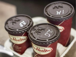Cups of coffee sit on a counter in a Tim Hortons outlet.