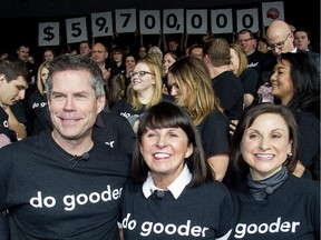 United Way Calgary and Area CEO Lucy Miller is flanked by 2014 co-chairs Dave Kelly and Gianna Manes as they raise the curtain on the year's record total of over $59 million raised in a ceremony at the Bow Tower Tuesday January 27, 2015.