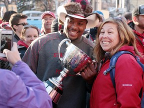 Red Deer's Michelle Skilmick posed for a photo with Nik Lewis and the Grey Cup following the Calgary Stampeders' Grey Cup celebration rally at Calgary City Hall on December 2, 2014. Lewis' popularity with Stamps fans is undeniable, but whether or not he finishes his career here remains to be seen.