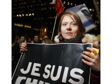 Mathilde Denier, living in Calgary but from France, holds the Je Suis Charlie banner at a candlelight vigil held Wednesday evening January 7, 2015 on the Calgary City Hall steps commemorating the 12 people murdered in the terror attack in Paris.