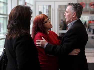 Sean Mahoney, right, husband of Kelly Jo Smith who was killed in a crash by a drunk driver, gets a hug from Karen Harrison, president of MADD, after sentencing of the accused at the Calgary Courts in Calgary January 16, 2015.