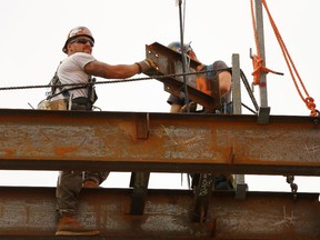 Construction worker working on the structural steel framework of the National Music Centre in Calgary on Friday May 23, 2014.