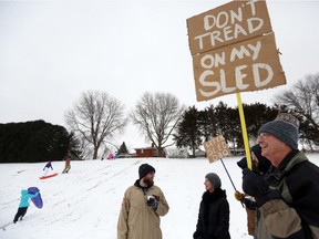 Dave Noel holds a sign protesting Dubuque, Iowa's banning of sledding on certain hills in the city.