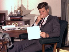 In this Jan. 18, 1962 file photo, U.S. President John F. Kennedy looks over notes at his desk in the White House. Kennedy was a participant in a landmark Harvard health study.