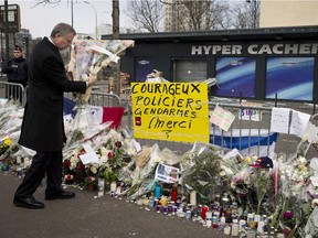 New York Mayor Bill de Blasio prepares to place flowers in front of the Hyper Cacher kosher supermarket in Paris on January 20, 2015, for the victims of the January 9 hostage-taking by jihadist gunman Amedy Coulibaly at the Jewish supermarket at Porte de Vincennes, which left four dead. Placard reads: "Courageous police and law-enforcement thank you".