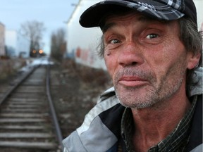 Alex Clarke stops along an abandoned rail spur as he walks to his homeless camp in a southeast industrial area of Calgary.