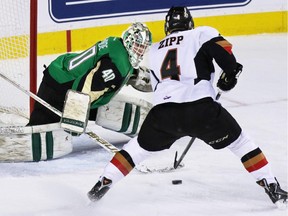 Calgary Hitmen Michael Zipp put this puck past Prince Albert Raiders goaltender Nick McBride to score the second of four goals in the first period of WHL action at the Scotiabank Saddledome on Friday January 30, 2015.