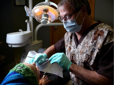 Dr. Dave Warwick works on patient Jill Moench, 12, at the Hanna Dental Clinic in Hanna, Alberta on January 7, 2015.