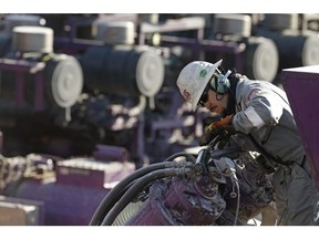 A worker oils a pump during a hydraulic fracturing operation near Mead, Colo.