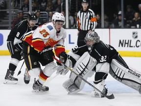 Los Angeles Kings goalie Jonathan Quick prevents Calgary Flames centre Sean Monahan from scoring as Kings defenseman Drew Doughty, rear left, also defends during the first period on Monday, Jan. 19, 2015, in Los Angeles.