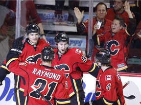 Calgary Flames' Josh Jooris, centre, celebrates his game winning goal against the Buffalo Sabres with teammates Joe Colborne, left to right, Mason Raymond and Kris Russell on Tuesday. After a 4-1 win, the Flames are hoping to continue that roll against the Minnesota Wild on Thursday.