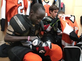 McKnight Mustangs Bantam 2 player Gathoth (Goose) Reth-Buob, left, was born in the Sudan before coming to Canada when he was two. His single mom doesn't drive, so he has relied on neighbour Karen Schwarzenberger and other parents from his hockey teams to drive him to the rink and donate equipment.