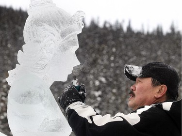 Thai sculpture Kla Kitburi, now living in Seattle, fine tunes his creation, Siamese Kinaree at the Ice Magic Festival on the shore of Lake Louise Saturday January 17, 2015 at the Ice Magic Festival. The sculpture was part of the International Ice Carving Competition in which 10 internationally accredited teams of 2 are given 15 blocks of ice and 34 hours to create a frozen masterpiece using the theme Wonders of the World.