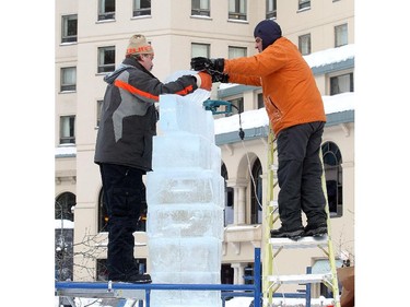 Zareh Nercissian , left, and Vahe Tokmayjan of Team Ararat place the face of Jesus onto their Christ the Redeemer sculpture at the Ice magic Festival on the shore of Lake Louise Saturday January 17, 2015 at the Ice Magic Festival. The sculpture was part of the International Ice Carving Competition in which 10 internationally accredited teams of 2 are given 15 blocks of ice and 34 hours to create a frozen masterpiece using the theme Wonders of the World.