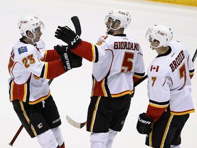 Calgary Flames' Mark Giordano (5) celebrates his goal against the Arizona Coyotes with teammates Sean Monahan (23) and T.J. Brodie (7) during the third period of an NHL hockey game Thursday, Jan. 15, 2015, in Glendale, Ariz. The Flames defeated the Coyotes 4-1.