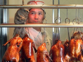 Chef  You-Guang Ding hangs Peking duck in the window of the butcher stall at T and T Supermarket Friday January 16, 2015.