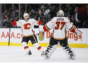 Calgary Flames centre Matt Stajan, left, and goalie Joni Ortio, right, celebrate after Dennis Wideman's overtime winner was upheld upon video review. The Flames won 2-1.