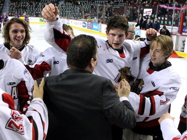 A blood soaked Cariboo Cougars defenceman Todd Bredo, centre, celebrated with teammates after the Cougars defeated the Regina Pat Canadians in the Max's AAA Midget Tournament male final 2-1 in double overtime at the Scotiabank Saddledome on January 1, 2015.