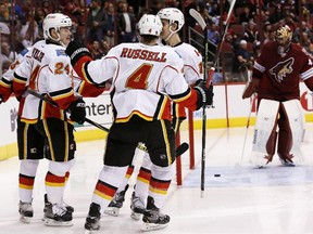 Calgary Flames' Mikael Backlund, right front, celebrates his goal against Arizona Coyotes' Mike Smith, right, with teammates Kris Russell (4); Jiri Hudler (24), and Johnny Gaudreau, left, during the second period on Thursday.