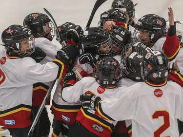 Bow Valley celebrates their overtime win against the Blackfoot Chiefs 3 B after winning the Novice South 4 finals of the ESSO minor hockey week in Calgary, on January 17, 2015.