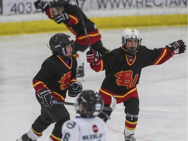 Novice Bow Valley 3 players celebrate after scoring a goal against Glenlake during the finals of the ESSO minor hockey week in Calgary, on January 17, 2015.