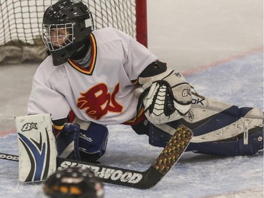 Novice 4's Bow Valley Flames' goalie watches the puck shot by the Blackfoot Chiefs skid by during the finals of the ESSO minor hockey week in Calgary, on January 17, 2015.