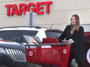 Melissa Brown pushes her loaded cart through the snow from the Target store at Market Mall Thursday January 15, 2015. She was one of many shoppers lamenting the impending closure of Canadian Target stores.