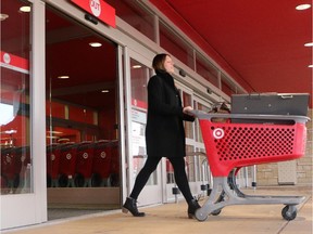 Melissa Brown pushes her loaded cart out the doors of the Market Mall Target store Thursday January 15, 2015, the day it was announced the company would be closing all it's Canadian outlets.