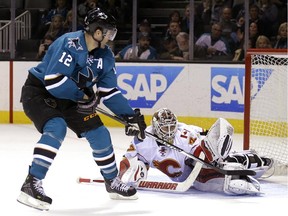 Calgary Flames' Joni Ortio, right, makes the save on a shot by San Jose Sharks' Patrick Marleau during the third period of an NHL game on Saturday. The Flames won in OT, to slip ahead of the Los Angeles Kings into the final playoff position in the Western Conference.