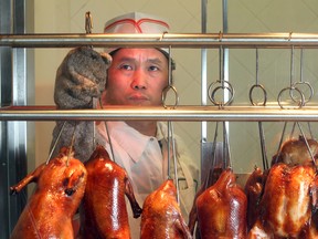 Chef You-Guang Ding hangs ducks in the window of the butcher stall at T and T Supermarket.