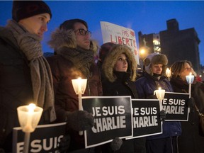 People gather in front of Montreal City Hall during a vigil following the deadly attack at the Paris office of Charlie Hebdo.