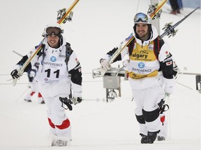 Canadian Philippe Marquis, centre, carries his skis with teammate Simon Pouliot-Cavanagh, left, following a training session for the upcoming men's World Cup freestyle moguls event in Calgary, Alta., Friday, Jan. 2, 2015.