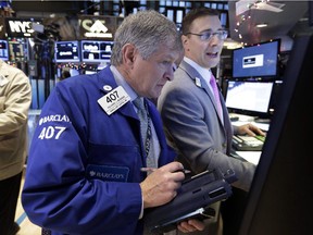 Trader Richard Newman, left, works on the floor of the New York Stock Exchange Monday, Jan. 5, 2015.