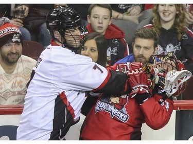 The Roughnecks Greg Harnett, right, takes a check to the neck from Vancouver Stealth's Tyler Digby during the Roughnecks home opener in Calgary, on January 3, 2015.  The Roughnecks couldn't pull it together eventually succumbing to the Stealth 18 to 14.