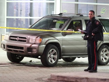 Police check out a possible second scene at the Emergency entrance to the Peter Lougheed Hospital, where a vehicle was taped off with a broken driver-side window.
