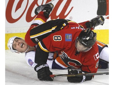 Joe Colborne of the Calgary Flames lands on top of Casey Cizikas of the New York Islanders behind the New York goal in the third period of the Flames 2-1 loss at the Saddledome Friday night January 2, 2015.