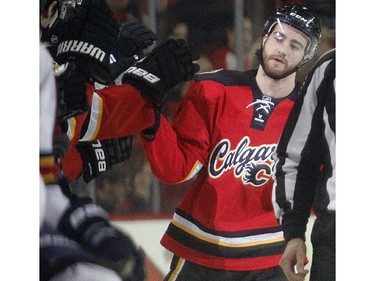 TJ Brodie of the Calgary Flames slaps hands at the bench after scoring his second goal of the game against the Florida Panthers during the second period Friday night January 10, 2015 at the Saddledome.