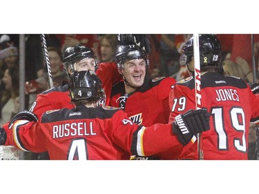 The Calgary Flames, from left, Kris Russel, Matt Stajan, Lance Bouma and David Jones, celebrate Stajan's third period goal in their  6-5 loss to the Florida Panthers Friday night January 10, 2015 at the Saddledome.