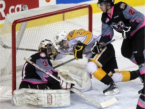 Brandon Wheat Kings' Reid Duke ends up in the net beind Calgary Hitmen goalie Mack Shields and Ben Thomas on Sunday. Brandon won 5-4.